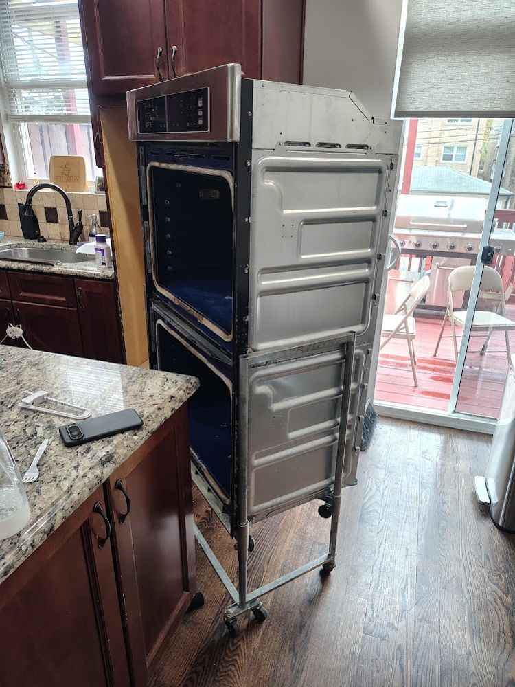 Double wall oven pulled out of its cabinet onto a cart for repair