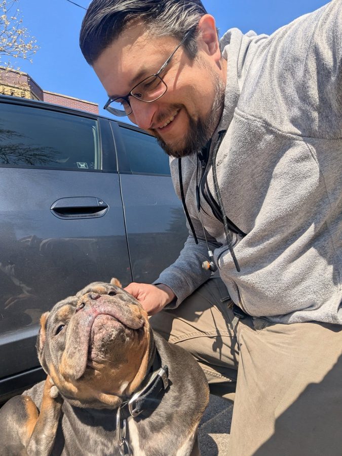 Max petting a customer's dog outside on a sunny day