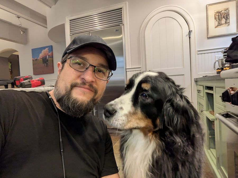Max with a customer's long-haired dog in their kitchen