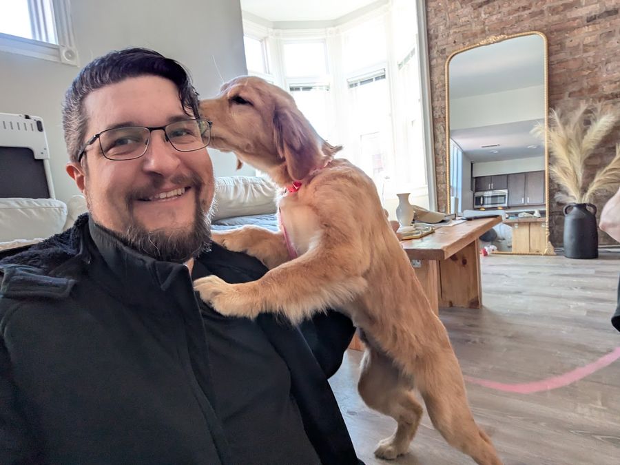 A customer's puppy jumping up to kiss Max